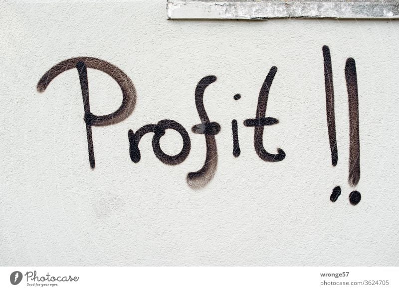 Graffito| the word profit !! sprayed with black paint on a light grey wall Word black color Spray Wall (building) Wall (barrier) upper-case letters Graffiti