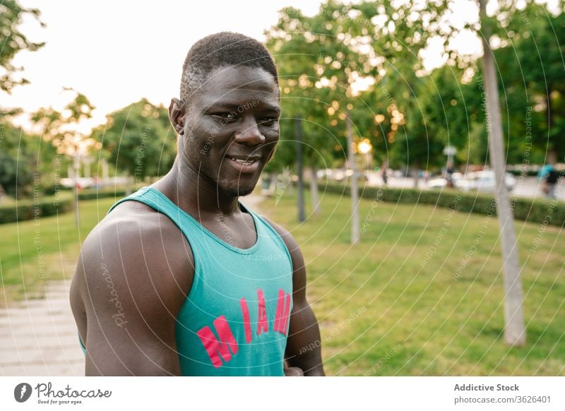 Portrait of athletic black man at the park african cheerful muscular fitness smiling strong flexing body muscle biceps happy arms athlete strength lifestyle