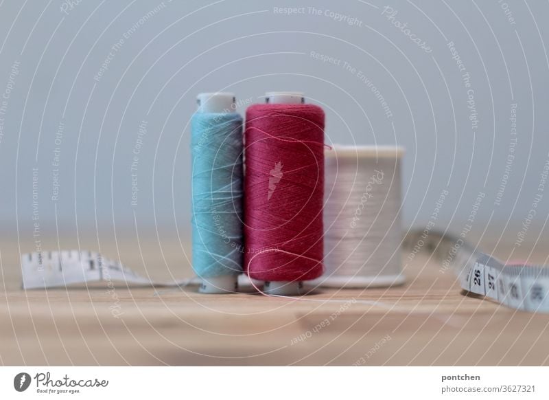 https://www.photocase.com/photos/3627321-sewing-threads-in-different-colours-and-a-measuring-tape-on-a-table-craft-sewing-dot-photocase-stock-photo-large.jpeg