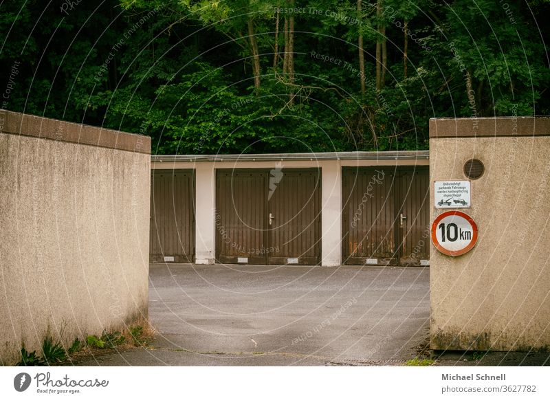Old garages in a garage yard in front of a forest area Garage Brown Gloomy slow down Exterior shot Colour photo Deserted