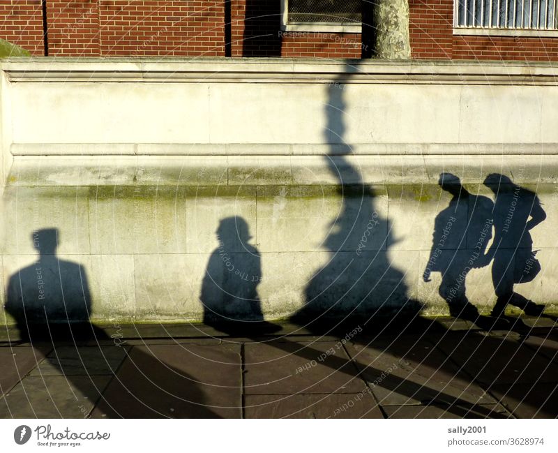 shadow play... Shadow Shadow play people Lamp post Couple hold hands Light Man Woman London England Brick wall off Cobbled pathway Together Interaction