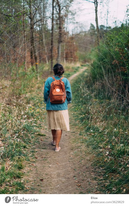 Woman from behind on a walk on a path through the forest Forest stroll To go for a walk Backpack spring Autumn Landscape Nature Going Lanes & trails Human being