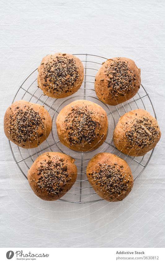Tasty homemade buns with mix of sesame seeds portion bread food natural bakery cooling rack fresh collection crispy similar assorted delectable brown surface