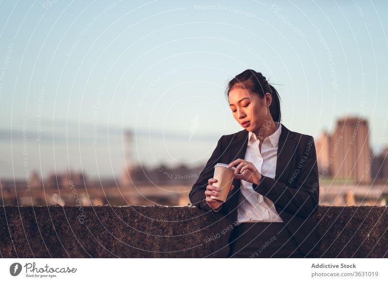 Young business woman holding a takeaway coffee businesswoman serious focus break young asian ethnic formal disposable cup rooftop to go drink modern female
