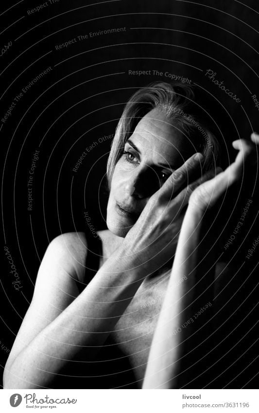 woman in a thoughtful and romantic attitude between light and shadow portrait people black and white one people asking silence gesture maturity adulthood