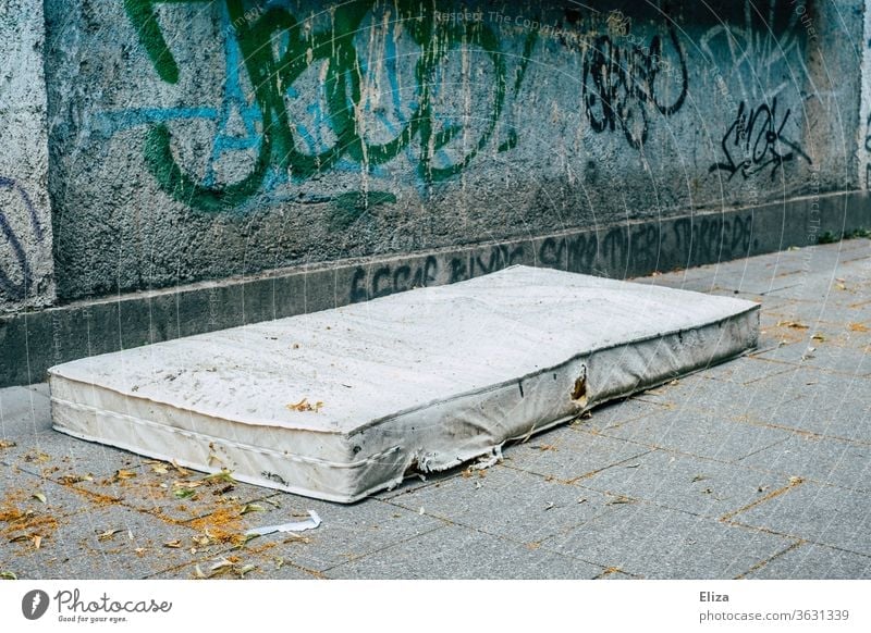 An old mattress on the street from graffiti. Concept of housing shortage and homelessness. House hunting Mattress Homelessness out Old Sleep Distress Poverty