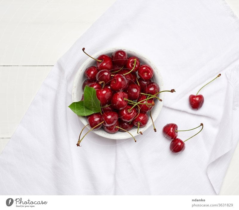 ripe red cherry in a round white wooden bowl on a white wooden background closeup crop delicious dessert agriculture berry bunch eating food fresh freshness