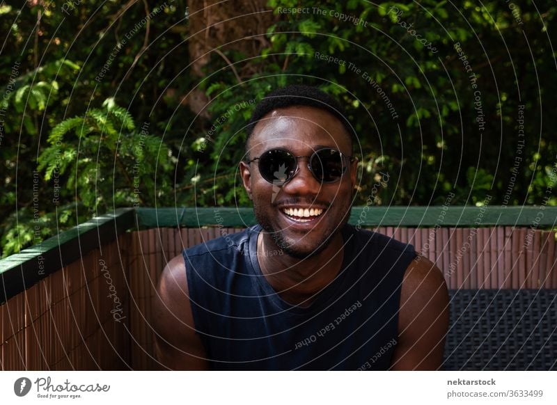 Young Black Man Towards Camera Outdoors 1 person African ethnicity man sunglasses lifestyle looking at camera terrace balcony summer tank top smile happiness