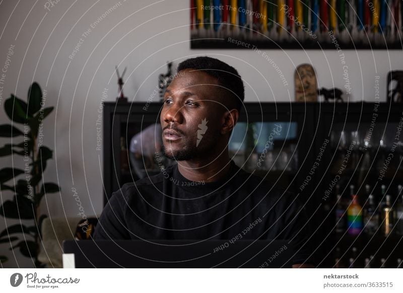 Portrait of Handsome Black Man Sitting in Living Room Looking Away man 1 person African ethnicity lifestyle 20-30 years old handsome domestic life young man