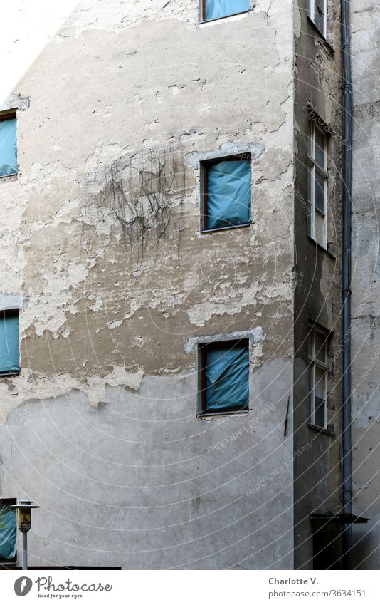 Old | house facade with flaking plaster, with blue tarpaulins instead of windows and a lamp Facade Flake off dilapidated Window hung imposed Rain gutter