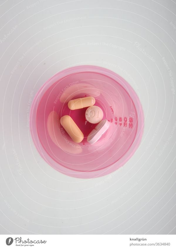 Pink plastic container with four different tablets from a bird's eye view Healthy Medication Pharmaceutics Pill Addiction Intoxicant Health care Drug addiction