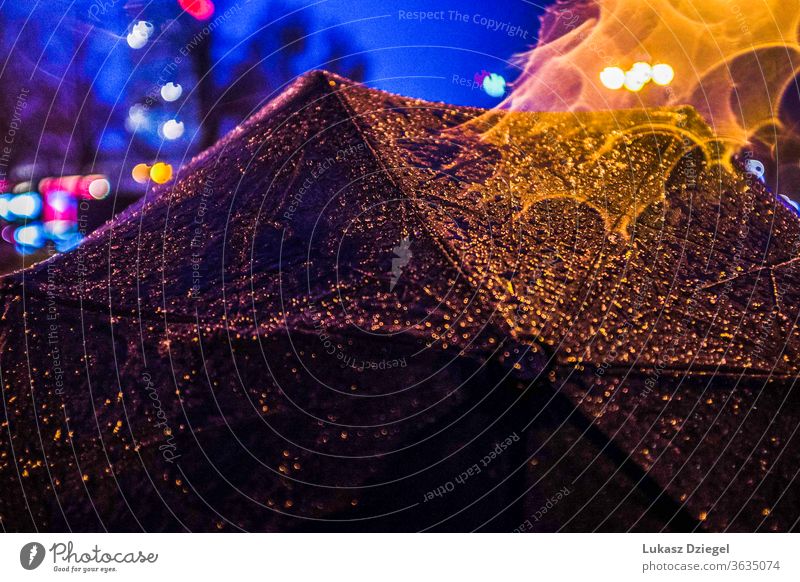 Close up of an umbrella with rain drops at evening rainwater close-up atmosphere night scene city objects water drops rainy alone night city dark nostalgia town