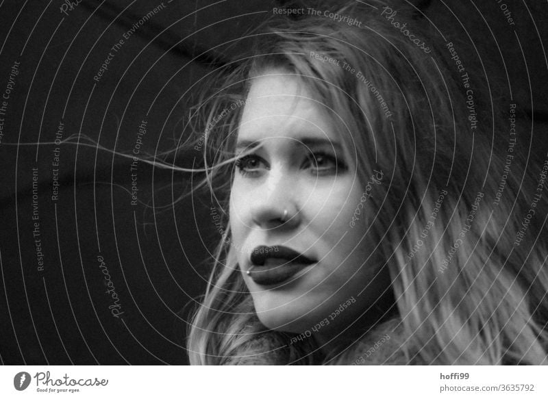 The young woman under the umbrella in wind and weather looks into the distance portrait Woman Young woman Face of a woman blurred background 18 - 30 years