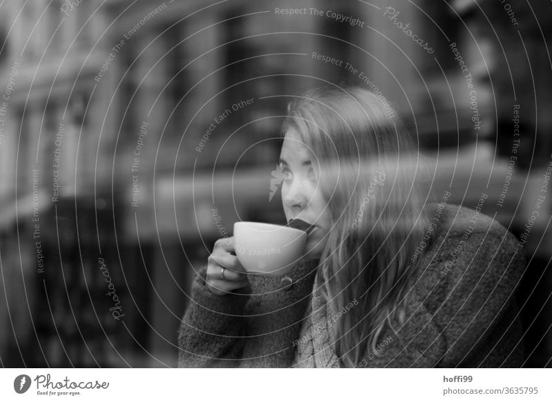 the young woman drinks coffee and looks through the window to the other side of the street To have a coffee Face of a woman Woman Young woman street coffee
