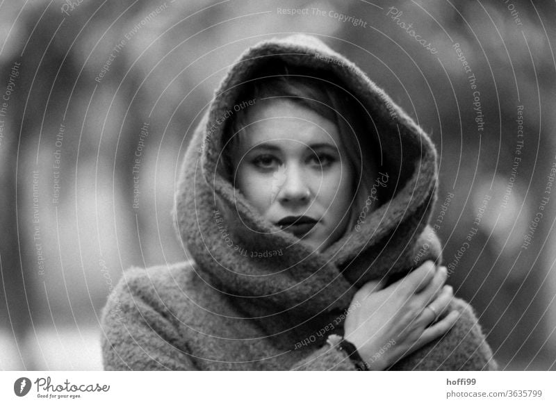 The young woman in the coat with hood looks into the camera portrait Woman Young woman Face of a woman blurred background 18 - 30 years Adults portraite