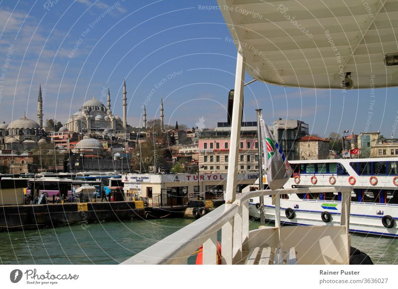 Istanbul, Turkey, 8 April 2015: A ferry approaches the station on a sunny day, revealing a beautiful view on the skyline of Istanbul. blue boat bosporus