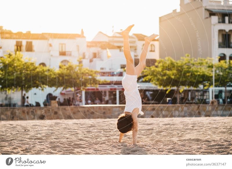 Little girl doing a handstand on the beach acrobatic active backlight balance beautiful child coast cute dance enjoy exercise fitness free freedom fun golden