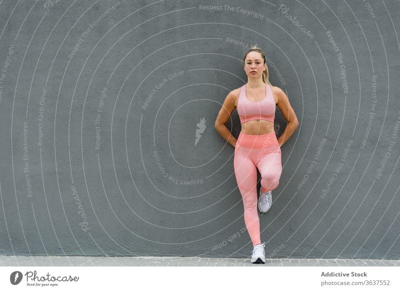 Full-length slim fit female in white sports attire. Woman standing on white  stairs relaxing during training stock photo