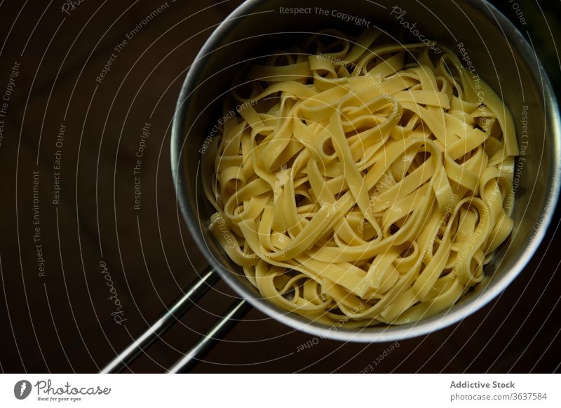 Freshly cooked spaghetti with boiled water pot pasta remove done al dente homemade utensil process prepare italian food tradition meal fresh pan liquid wavy hot
