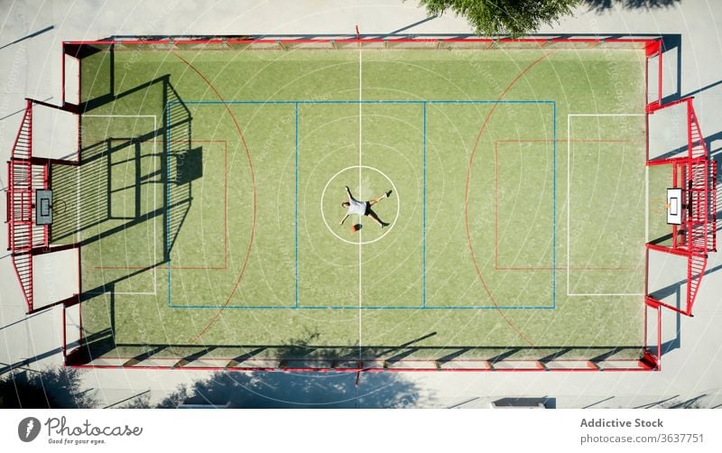 Basketball player relaxing on playground basketball woman rest lying tired sport court sportswoman circle athlete sportswear training activity game workout