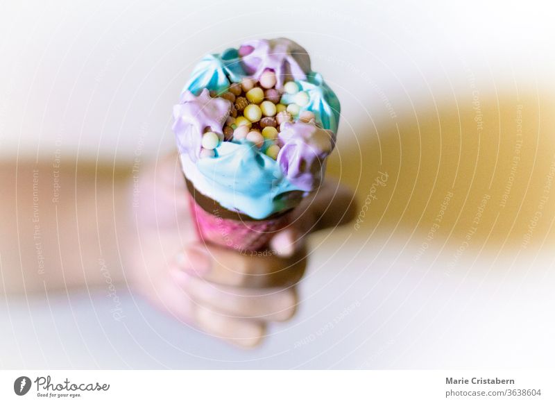 Shallow Depth of Field Shot of a Hand Holding a Colorful Rainbow Theme Icecream color cold delicious food background confection hand no people soft focus frozen