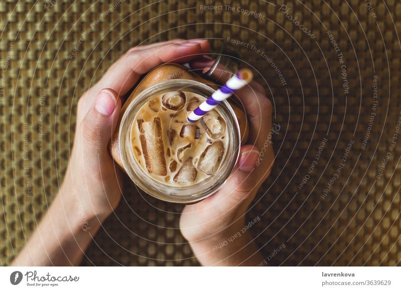 Flatlay of mason jar with iced tea or coffee, selective focus beverage caffeine cold cool drink female fingers food hands healthy holding natural paper straw