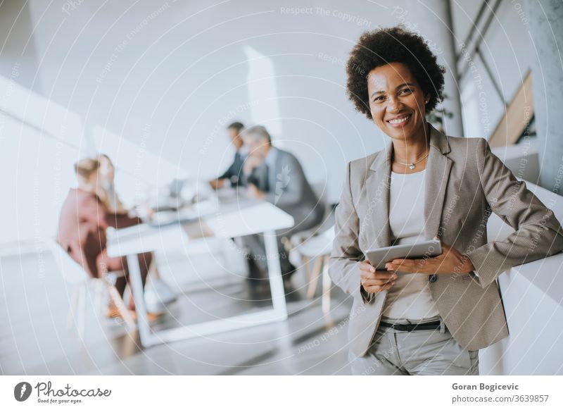 Young African American businesswoman standing using digital tablet in a modern office female black technology work young corporate african professional