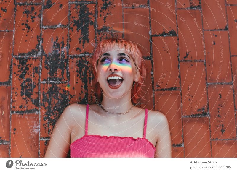 Happy woman lying on brick floor millennial pink hair carefree rainbow expressive female different creative modern happy trendy street style smile lady urban