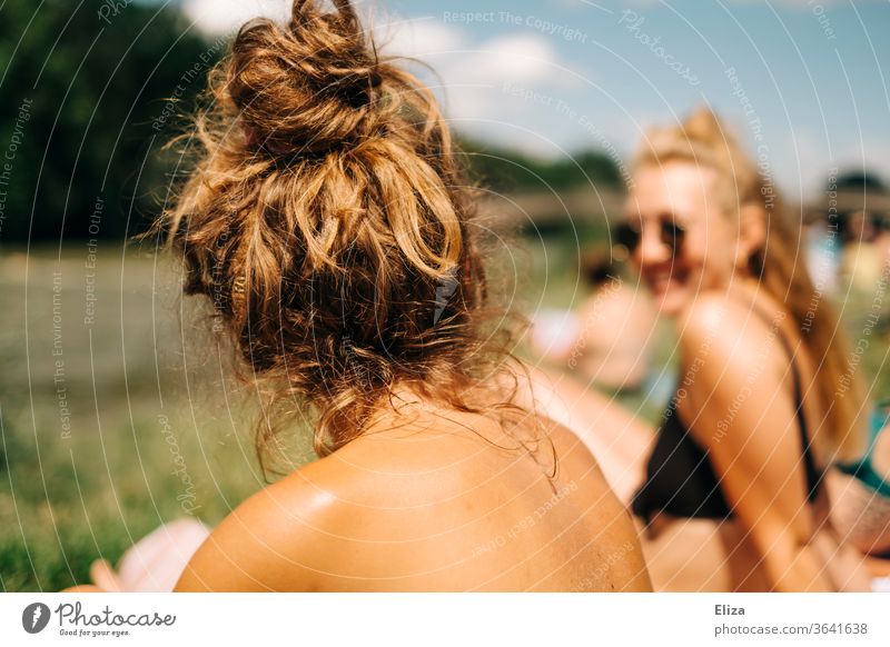 Two young women in bikini sunbathing in summer. Woman sunbathe Summer sunshine Sunbathing Bikini namely girlfriends from behind Summer vacation Holiday at home