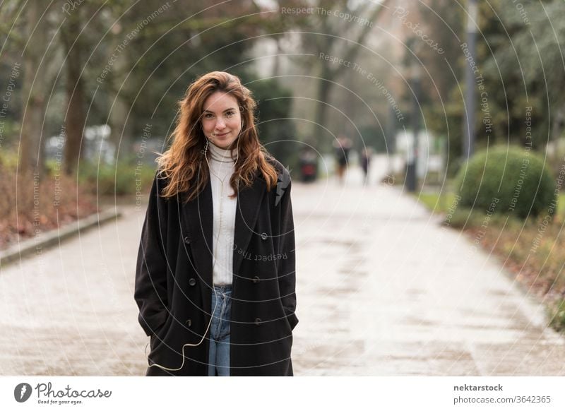 Beautiful Young Woman Smiling on Park Public Road caucasian ethnicity woman female earphones audio music listening brown hair real life model real person urban