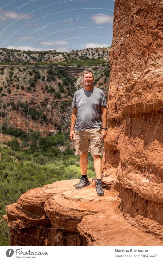 Man standing on the edge of the Lighthouse Rock, Palo Duro Canyin State Park, Texas man 50-54 hiking hike active lighthouse rock canyon desert dramatic clouds