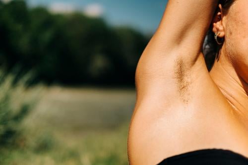 Woman raises her arm and you can see her armpit hair Underarm hair Hair Armpit Unshaven Feminism beauty ideal natural Emancipation body hair Summer Bikini out