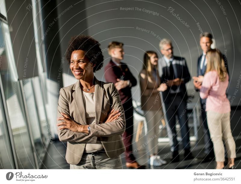 African American business woman standing in front of her team in