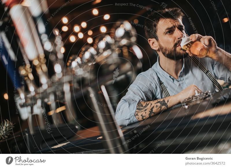 Man drinking beer and smoking cigarette at pub in the night club alcohol bad bar beard casual caucasian concept cool drunk glass guy habit handsome indoors male