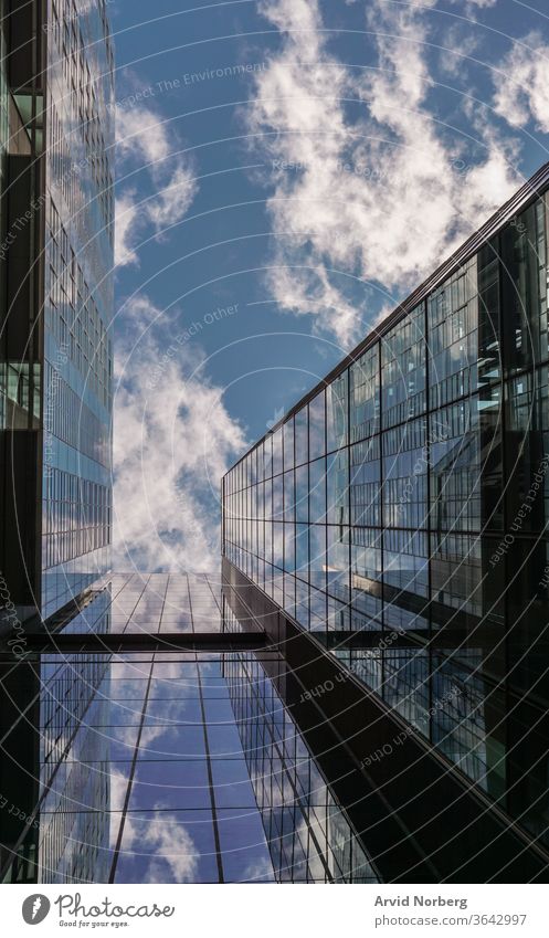 Looking up on a building with reflecting glass windows angle architecture background blue buildings business city cityscape clouds commercial corporate district