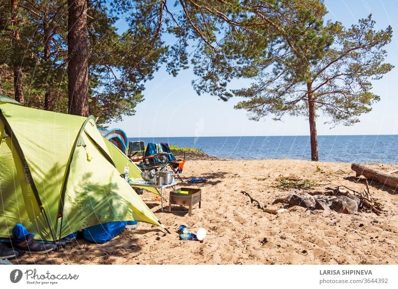 Camping and tent on the beach sea under the pine forest on the shore of the Gulf of Finland, St. Petersburg, Russia. Concept of outdoor activities, healthy lifestyle
