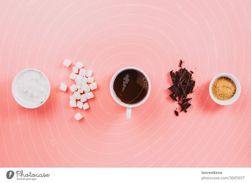 Flatlay of vegan cocoa, chocolate, coconut cream, sugar and vegetarian marshmallows on pink fall winter autumn ingredient flat cozy flatlay table cafe cup