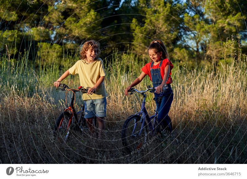 Ten-year-old boy and girl cycling through the countryside joy smiling kid bicycle enjoyment lifestyle children fun outdoorsy bike exploration exercising