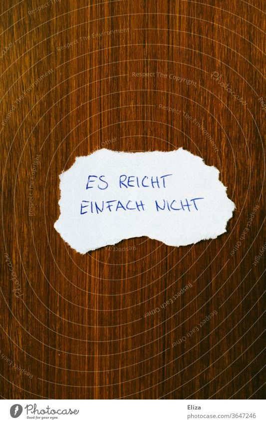 A note that says "It's just not enough." Poverty Money worries Shortage of money too little it will not suffice scarcity Lacking Emotions Divide call it a day