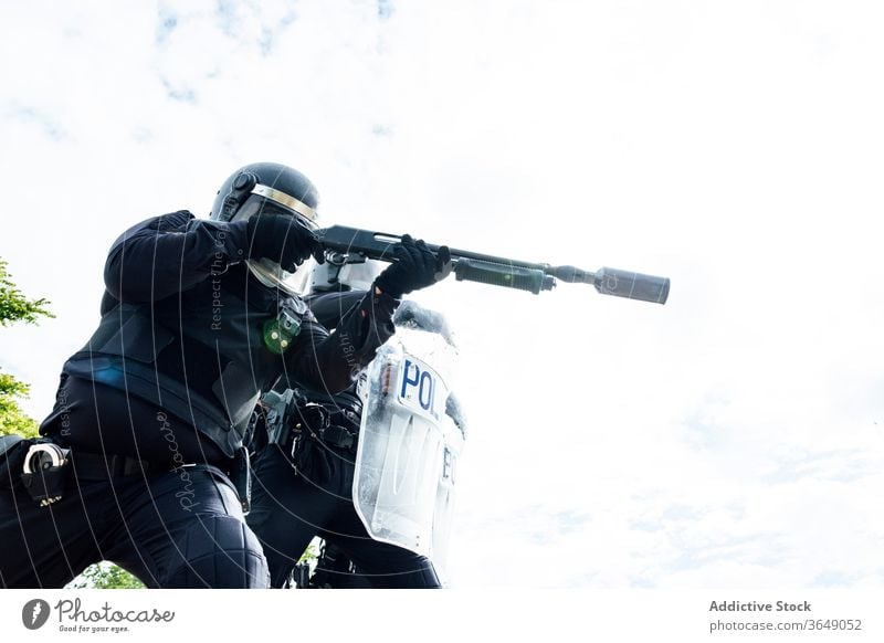 Professional policemen in protective gear during dangerous operation swat fight assault rifle shield equipment uniform partner helmet security weapon service