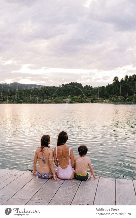 Calm children enjoying amazing view of lake vacation summer admire calm pond swimwear sibling scenery majestic together relationship friendship friendly bonding