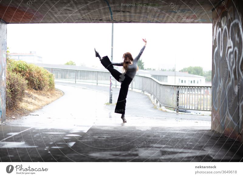 One Leg Hold Ballet in Front of City Underpass Entrance stand dancer female one leg hold one person girl tunnel underpass rainy elegance grace modern dance