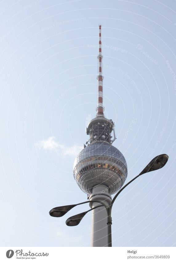 necklace - three-armed lamp stands decoratively in front of the Berlin television tower, the sky is blue with a little cloud Television tower Lamp streetlamp
