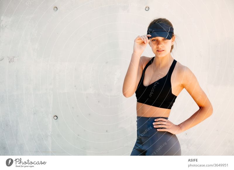 Fitness woman in sportswear outfit training on waterfront harbour