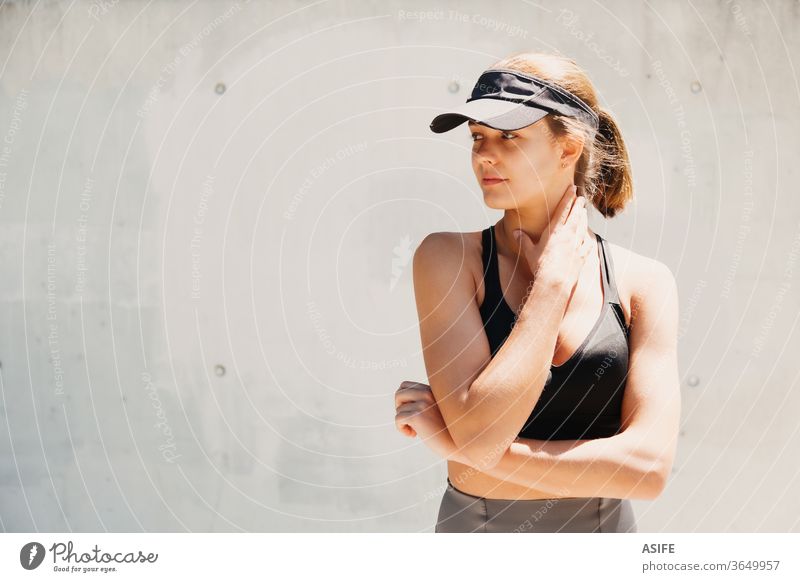 Portrait of a beautiful young sporty woman with visor cap in a hot day model fashion portrait posing running isolated happy smiling runner wall athlete gorgeous