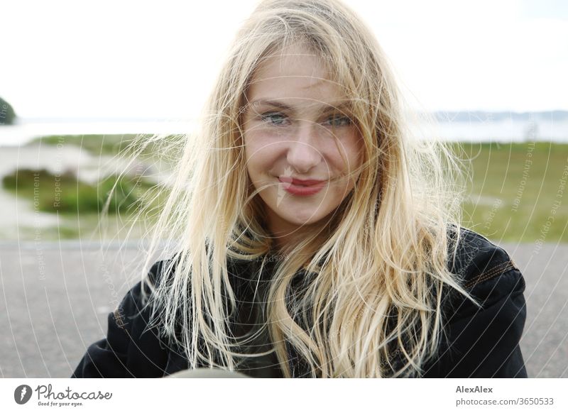 Backlit portrait of a young, blond, smiling woman at the sea Woman Young woman Blonde already Slim Long-haired windy Esthetic Summer Trip Beautiful weather