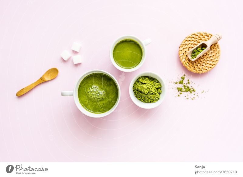 Matcha latte in two white cups and powder in a bowl on a pink background. Flat lay, ingredients. green Tea Beverage Matcha tea Powder Drinking Beater Japanese