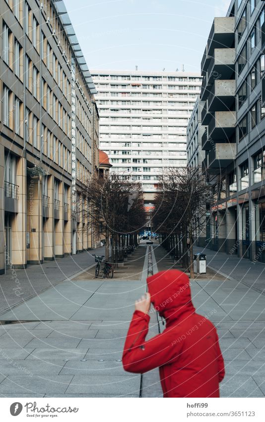 a person with a red jacket sneaks through the middle and through the picture Red red cap hood Berlin Middle Berlin Centre Avenue Capital city Downtown Berlin