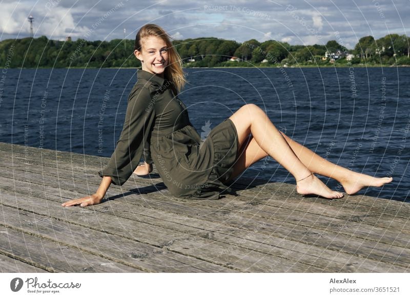 Full body portrait of a young, blond, barefoot woman on a wooden jetty in the sea Woman Young woman Blonde already Slim Long-haired windy Esthetic Summer Trip