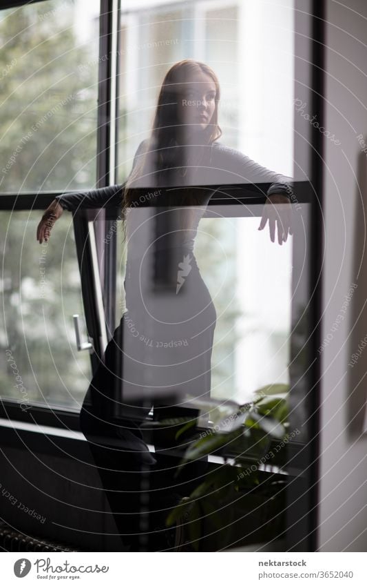 Attractive Woman Behind Glass Wall Partition female one person girl young woman glass silhouette three quarter length window contemplation thought looking away